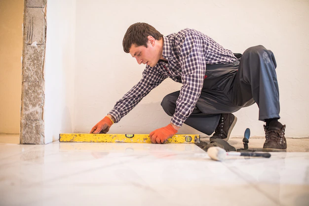 Homem instalando porcelanato no chão